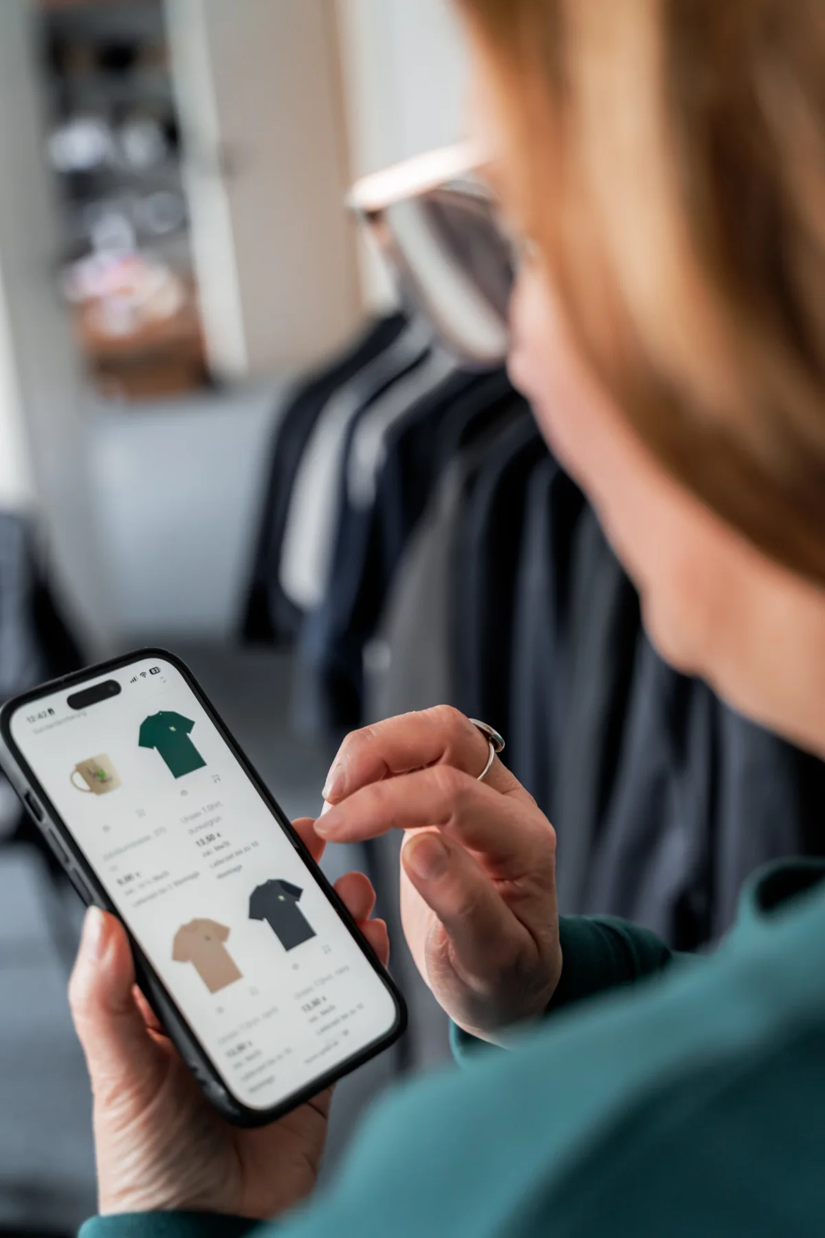 Mitarbeiterin bestellt Teamkleidung im Mitarbeitershop auf dem Smartphone